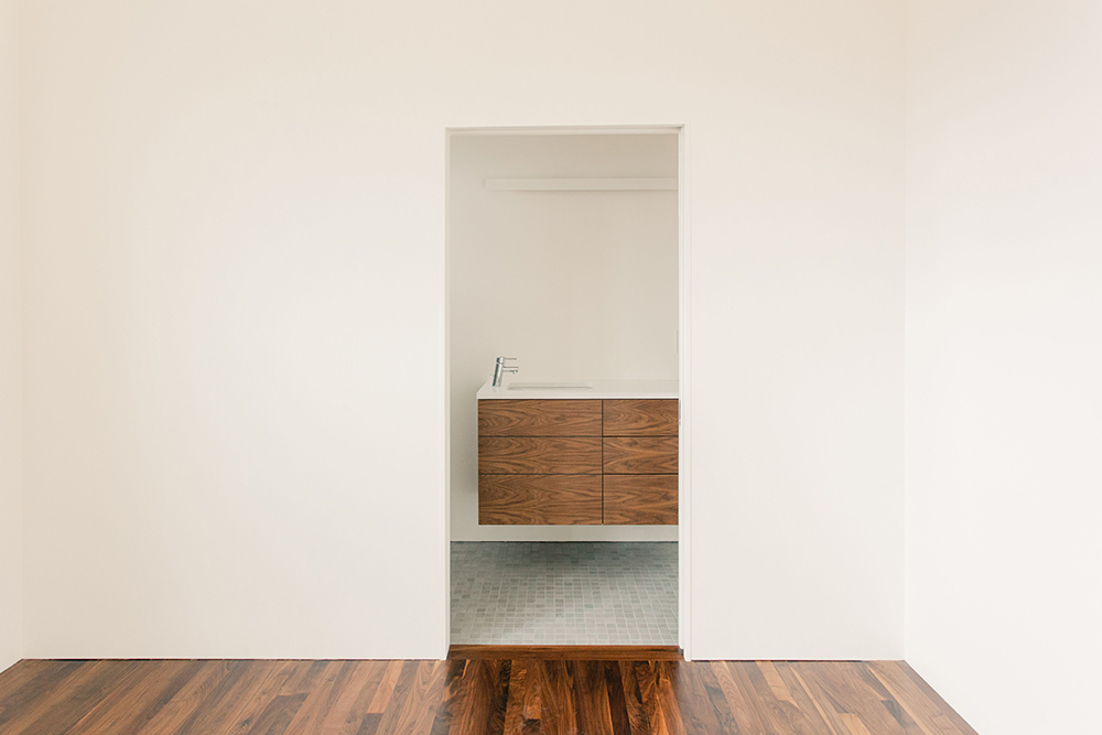 custom bathroom entrance with hardwood floor transitioning to tile
