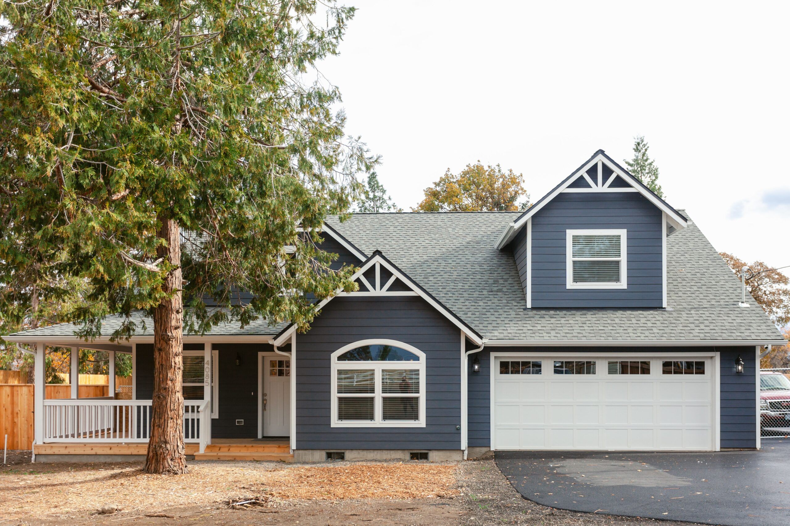 Front view of a custom built traditional farmhouse style home with a garage in Oregon